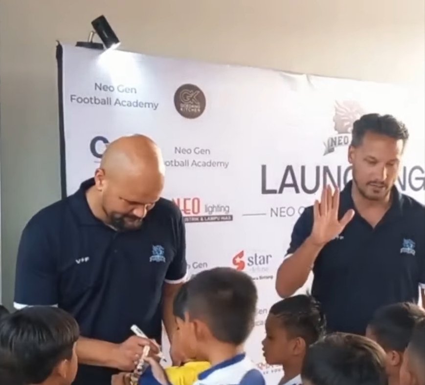 Raphael Maitimo signs autographs for young players next to Sergio Van Dijk at the Neo Gen Football Academy launch in Bandung